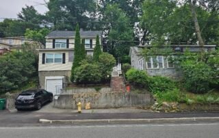 Overgrown shrubs and trees in front yard before landscaping maintenance