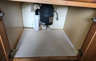 Installed garbage disposal and plumbing under kitchen sink in cabinet