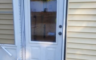Newly installed white exterior door with glass panel for residential entry