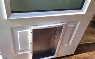 Newly installed pet door on white entry door for convenient outdoor access
