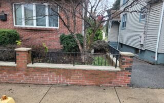 Residential front yard with shrubs and tree before professional landscaping