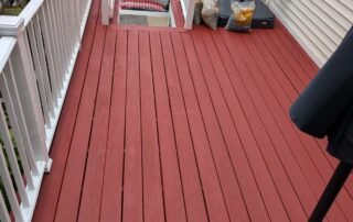 Freshly painted red deck with white railings at residential property