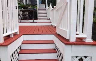 Freshly painted red and white deck with stairs, railings, and outdoor seating
