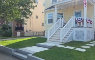 Neatly maintained front yard with stone walkway and fresh green lawn