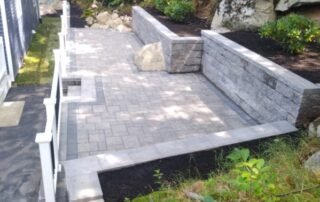 Stone patio with retaining walls and garden beds built into hillside